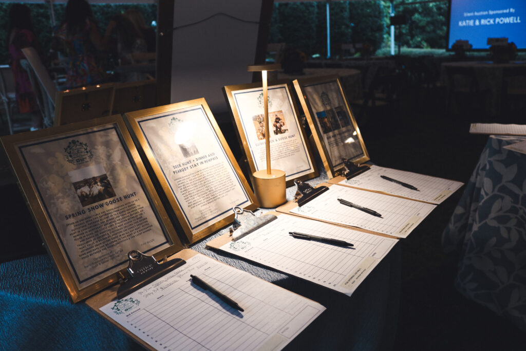 silent auction table featuring wine, Grizzlies apparel, and more for a nonprofit event