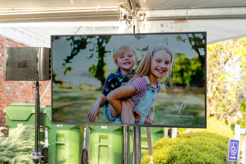 tv with palmer home for children graphic at an event