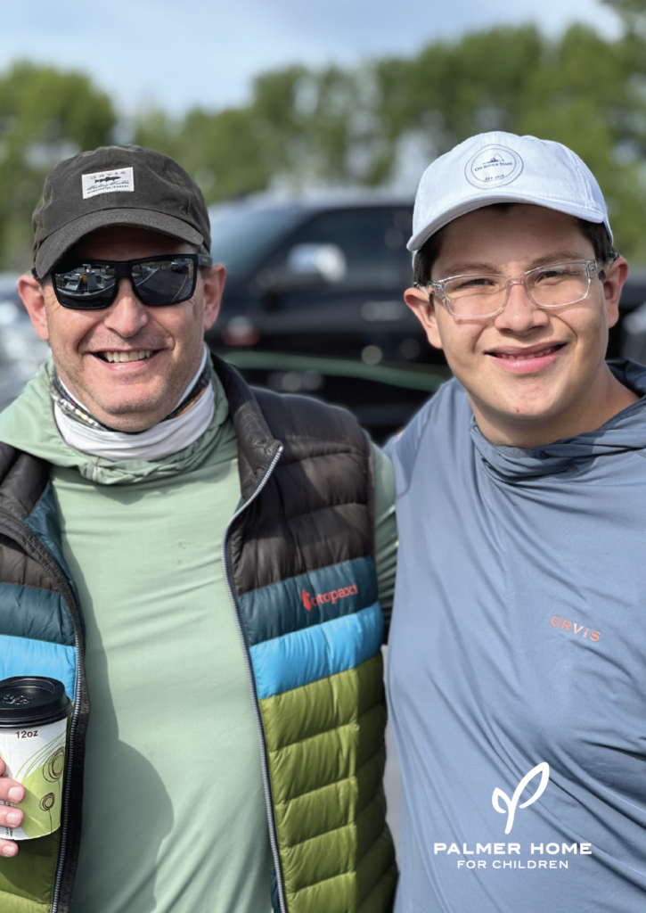 Man and boy on fishing trip smiling at the camera