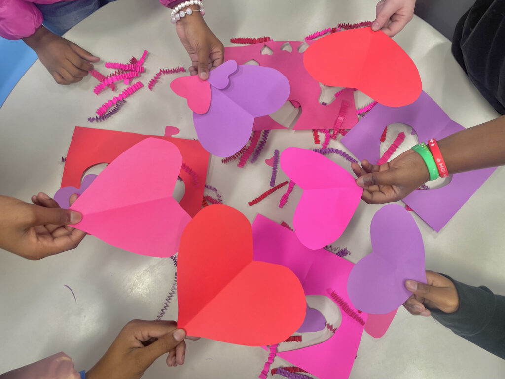 a group of children holding paper hearts